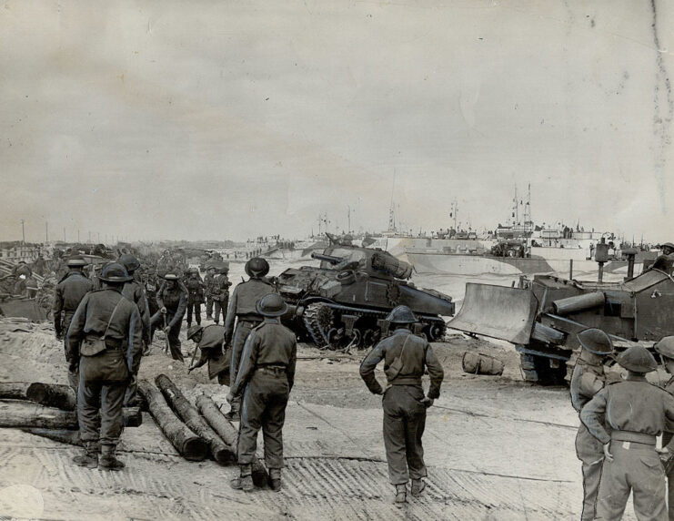 Canadian troops spread out across a beach with equipment
