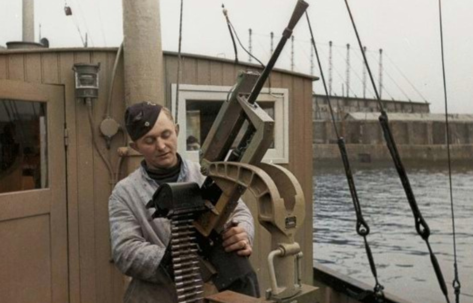 Soldier manning a Darne machine gun on a boat