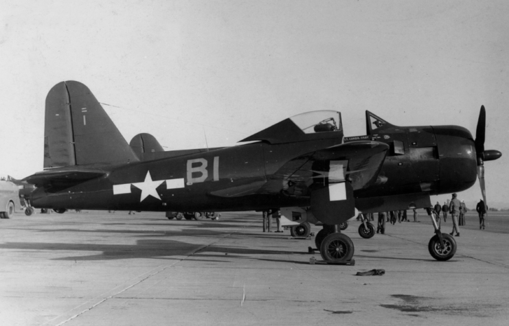 Crewmen walking near a Ryan FR-1 Fireball parked on the tarmac