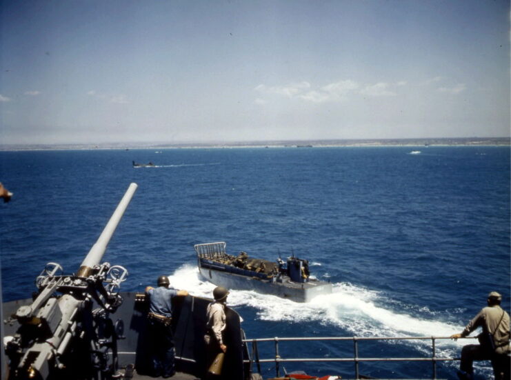 Landing craft traveling past the USS Leonard Wood (APA-12) at sea