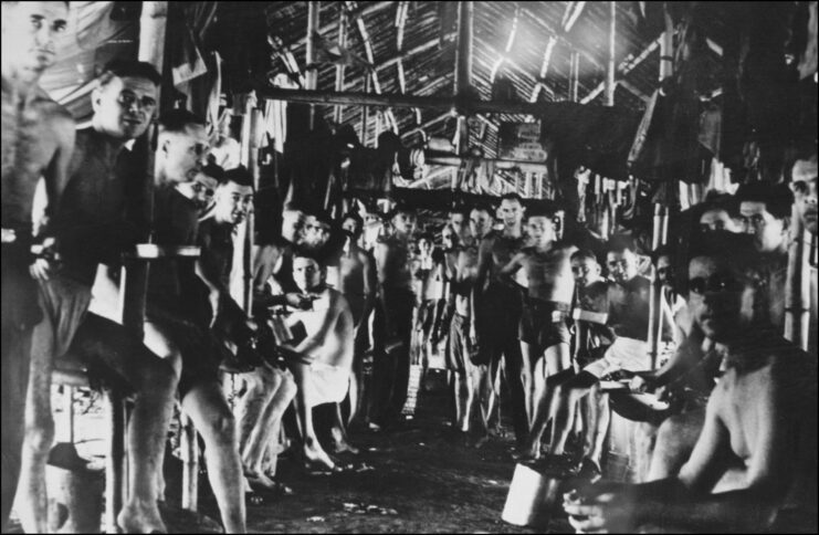 Prisoners of war (POWs) sitting within a wooden building