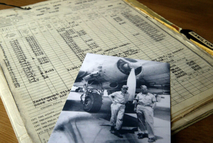 Photograph of Lee Hamilton and another airman placed atop a flight log