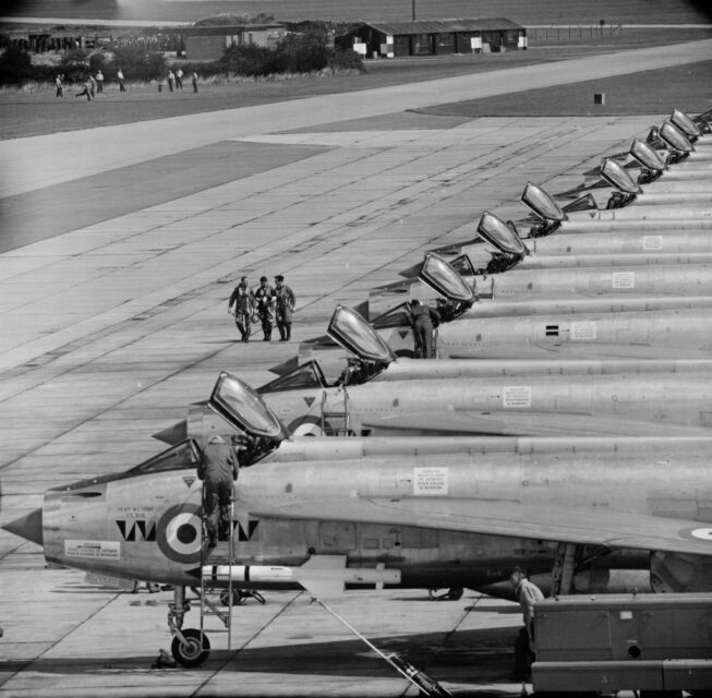 Members of No. 74 Squadron RAF walking past a row of English Electric Lightnings