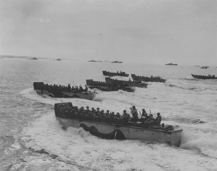 Several landing craft making their way through rough seas