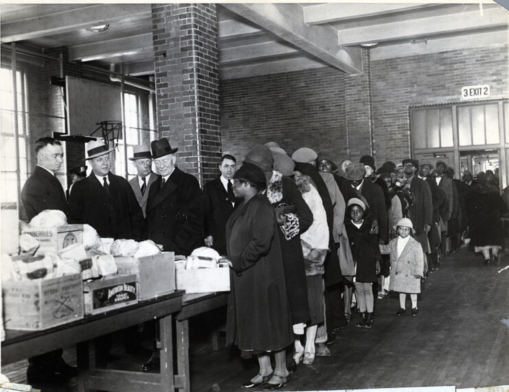 People lining up before New York Police officers who are standing behind a table covered in food supplies