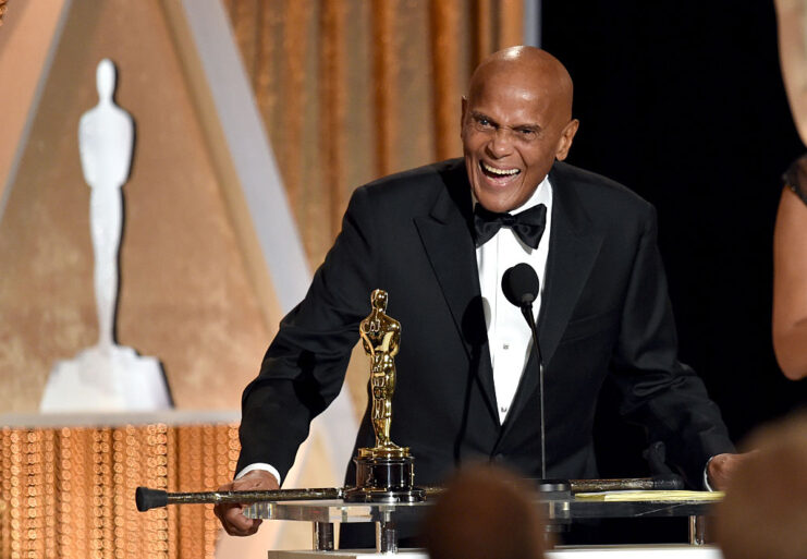 Harry Belafonte speaking at a podium, with his Academy Award placed atop it