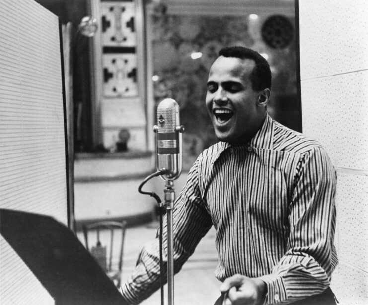 Harry Belafonte singing into a microphone in a recording booth