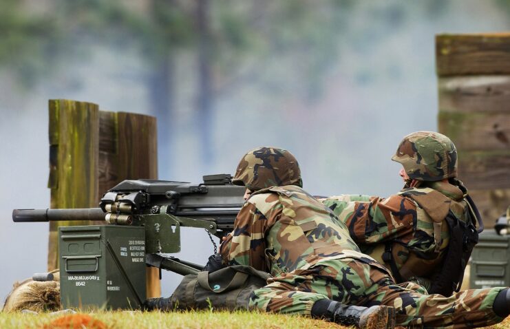 Two US Navy sailors aiming an Mk 19 grenade launcher