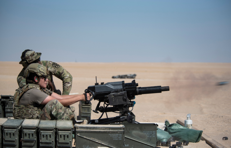 US Air Force member watching as Senior Airman Monica Roybal fires an Mk 47 Striker