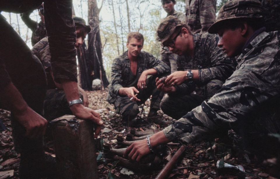 US Army Special Forces members and South Vietnamese soldiers crouching in the jungle