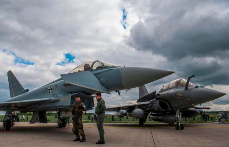 Two men standing near a Eurofighter Typhoon and a Dassault Rafale