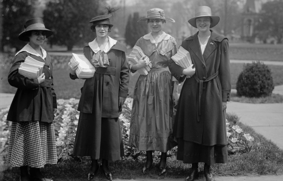 Four women holding pamphlets outside