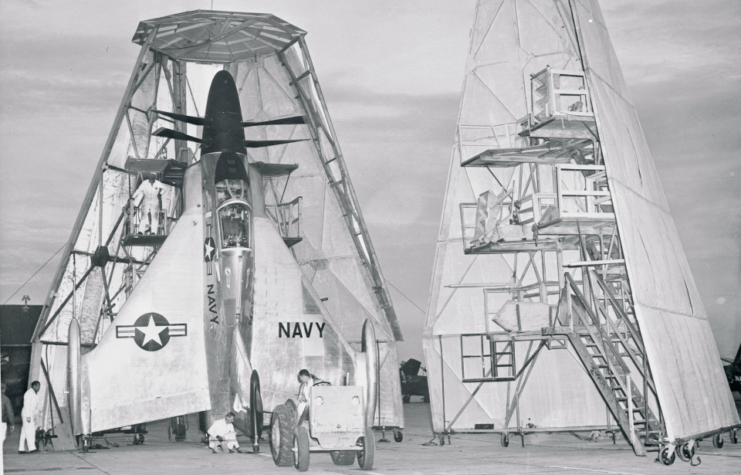 Crewmen placing a Convair XFY-1 Pogo in a cone-shaped aircraft hangar