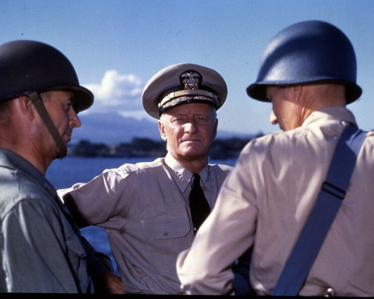 Chester W. Nimitz speaking with two US Navy personnel