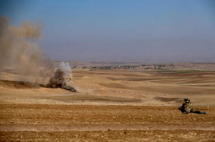 Syrian Democratic Forces (SDF) fighter lying on his stomach in the Syrian desert