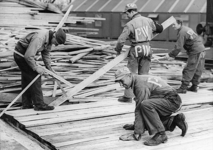 Four German prisoners of war (POWs) working with planks of wood