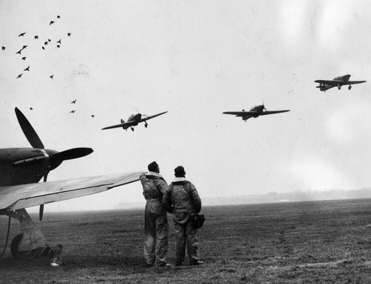 Two Czech pilots watching Hawker Hurricanes in flight