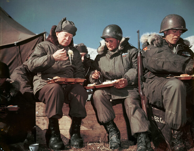 Dwight D. Eisenhower eating a meal with two other US military officials
