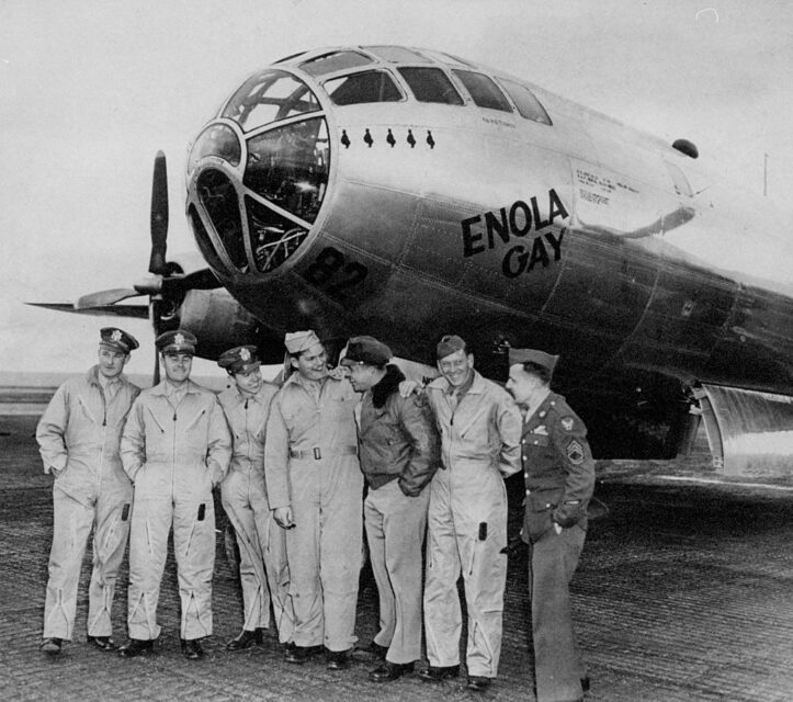 Thomas Ferebee, Paul Tibbetts Jr., Theodore Van Kirk, Kermit Beahan, Robert Lewis, Wyatt Duzenbury and George Caron standing in front of the Boeing B-29 Superfortress 'Enola Gay'