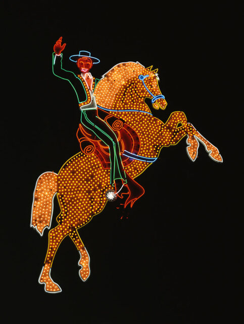 Neon sign featuring a mariachi performer on horseback