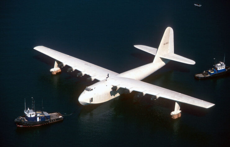 Two tugboats sailing near the Hughes H-4 Hercules