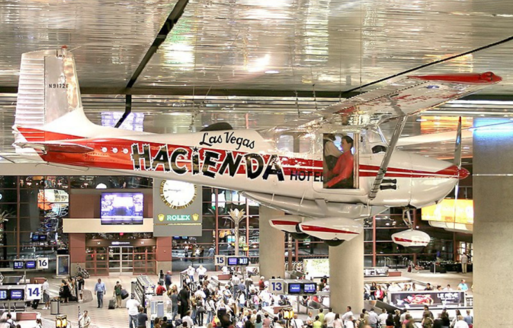 Crowds walking beneath a Cessna 172 hanging from the ceiling of Harry Reid International Airport