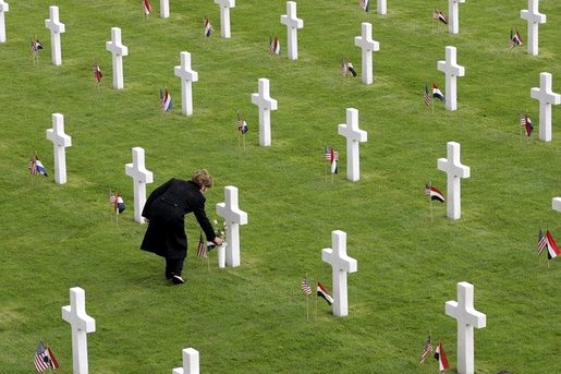 First Lady Laura Bush laying flowers at a grave at Margraten American Cemetery