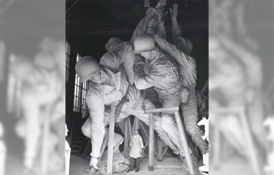 Felix de Weldon standing beneath a plaster cast of 'Raising the Flag on Iwo Jima'