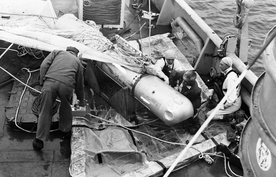 Ship crewmen standing around a hydrogen bomb