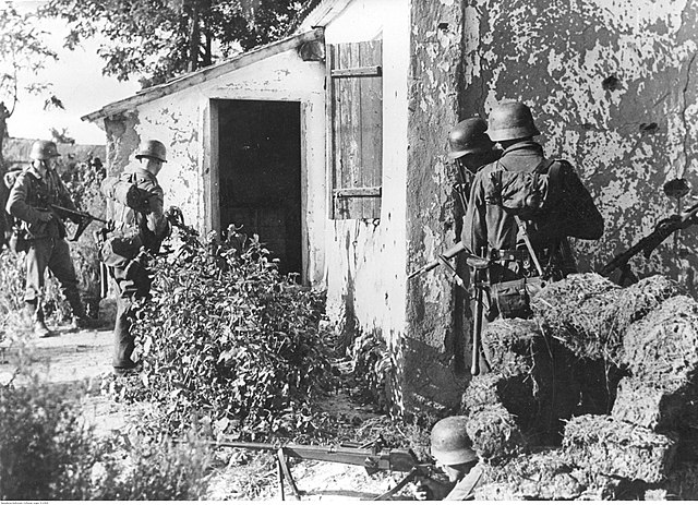 Four German soldiers preparing to enter a residence