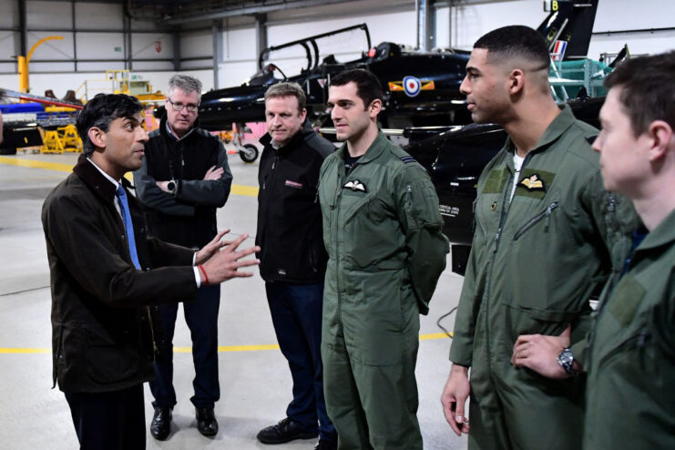 Rishi Sunak speaking with three Royal Air Force (RAF) trainees while two other officials watch on