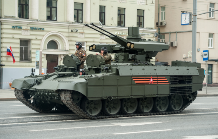 Three Russian soldiers manning a BMPT-72 Terminator 2 on a city street
