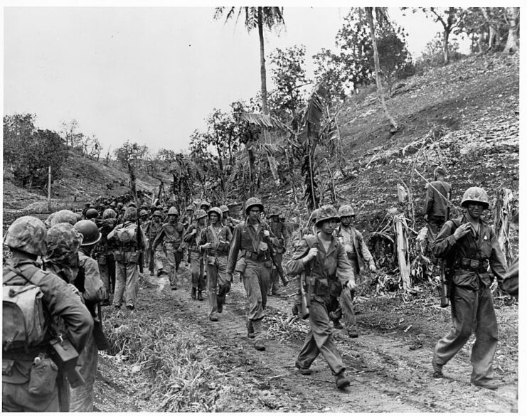 US Marines walking along a dirt road on Saipan