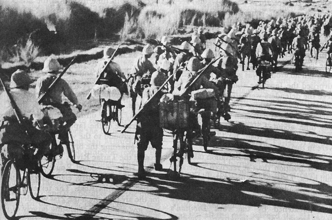 Japanese troops riding bicycles down a road