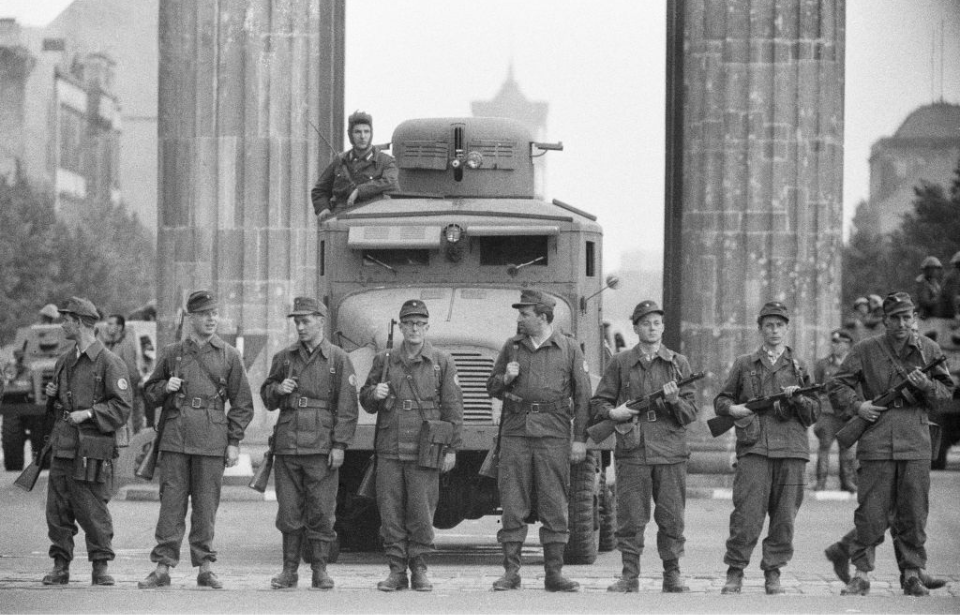 Members of the Combat Groups of the Working Class standing in front of the beginnings of the Berlin Wall