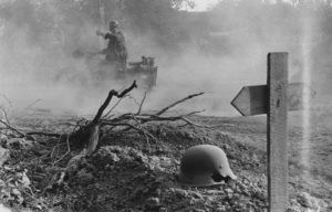 British soldiers traveling past a makeshift German grave in Normandy