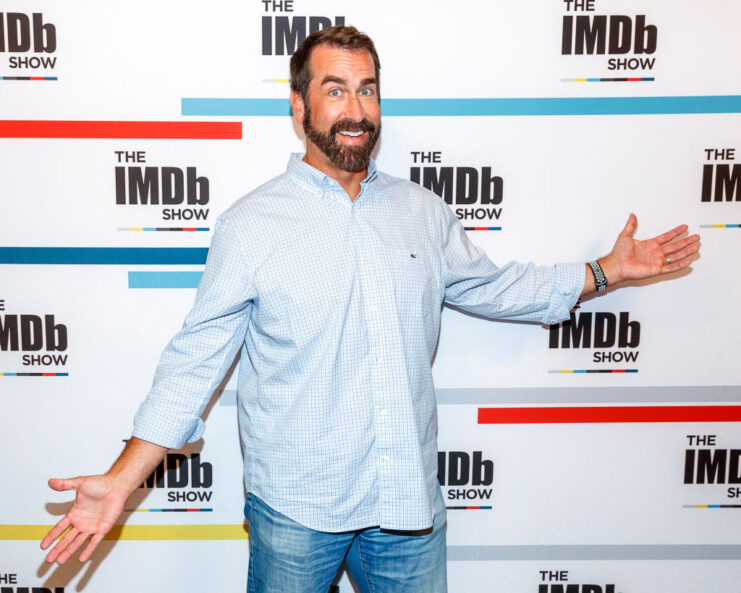 Rob Riggle standing on a red carpet
