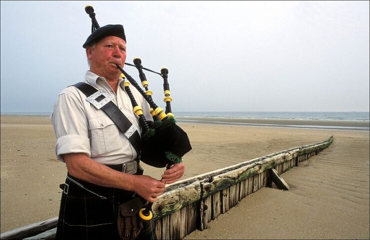 Bill Millin playing the bagpipes on the beach