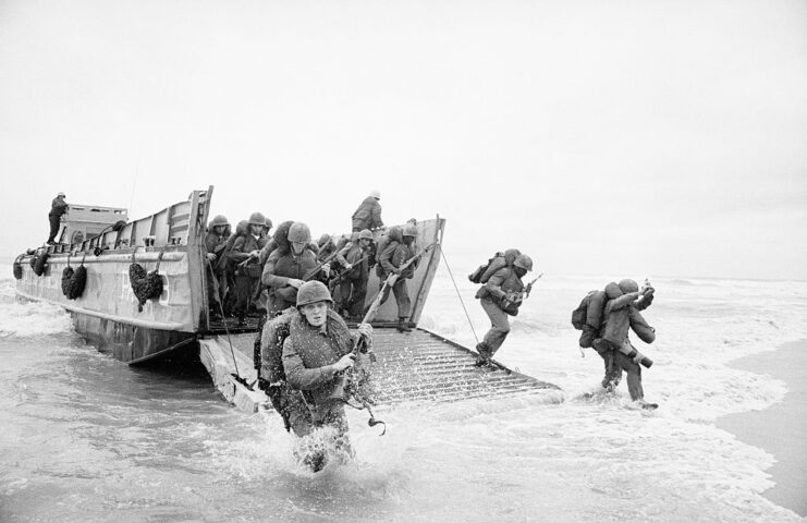 US Marines disembarking from a landing craft, onto a beach