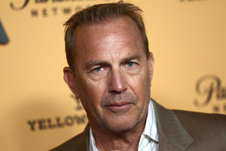 Kevin Costner standing on a red carpet