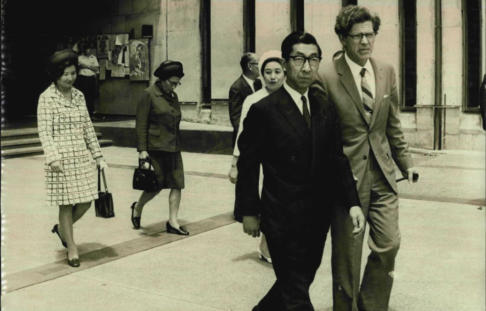 Professor B. Williams and Takahito, Prince Mikasa walking near a building