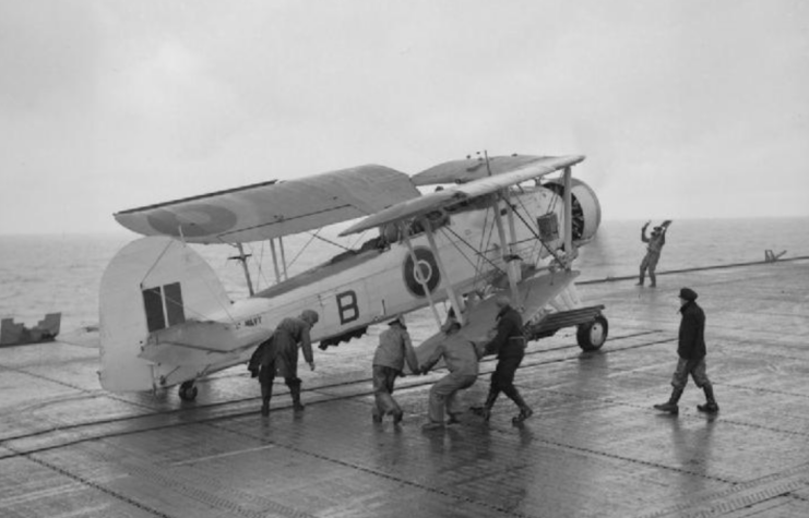 Men walking around a Fairey Swordfish with its wings folded