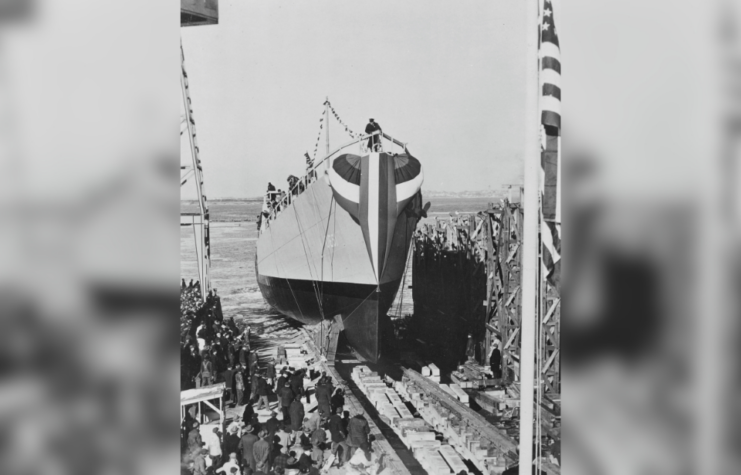 Crowd gathered around the USS Buckley (DE-51) as she's being backed into the water from dry dock