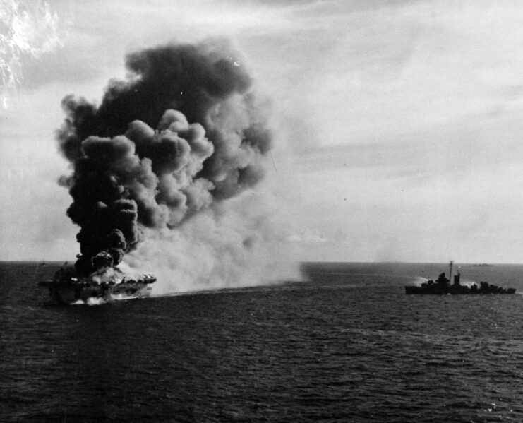 USS Patterson (DD-392) transiting near the USS Ommaney Bay (CVE-79) while she's shrouded in smoke