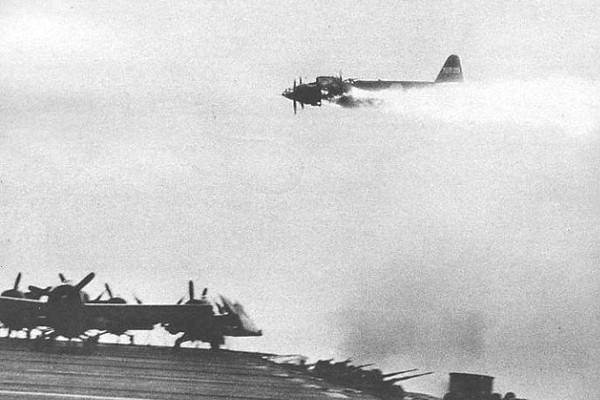 Yokosuka P1Y flying over the flight deck of the USS Ommaney Bay (CVE-79)