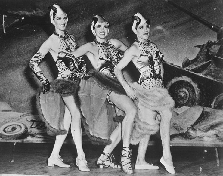 Three servicemen posing together while dressed in drag