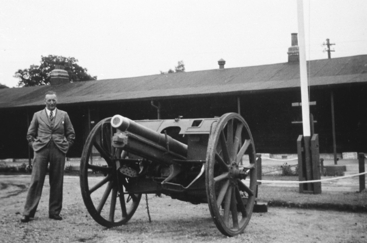 Albert Baker standing next to the gun captured at Graincourt-lès-Havrincourt