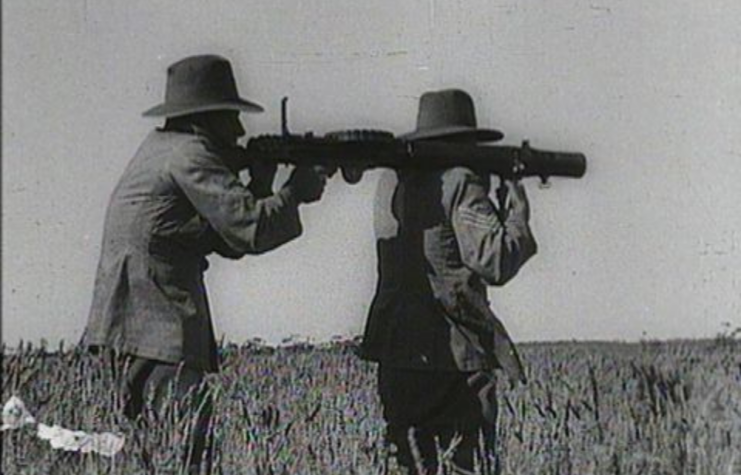 Two Australian soldiers manning a Lewis gun in a wheat field