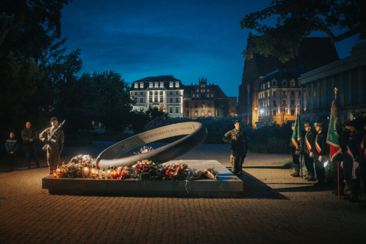 Members of the Army of the Land Forces standing guard around a monument in the middle of the night