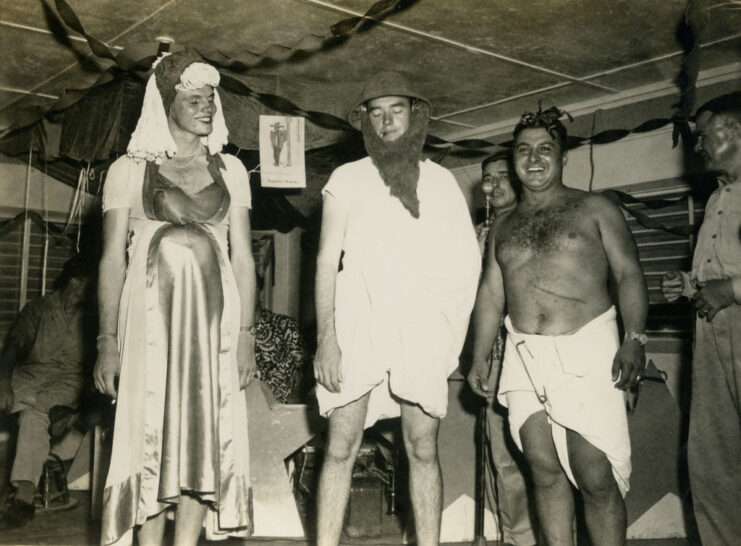 Three servicemen dressed as a woman, a bearded man and a baby